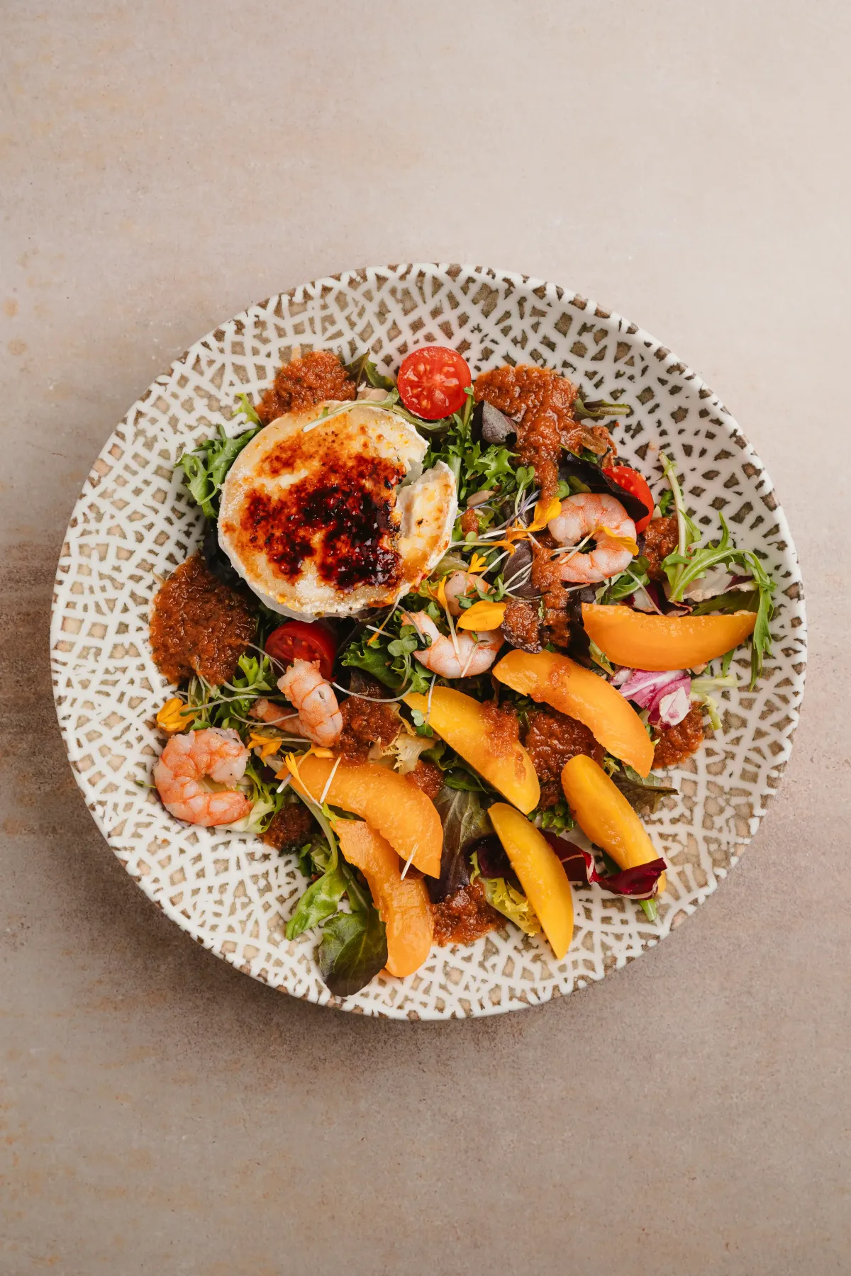 Ensalada templada de queso de cabra, gambas y fruta